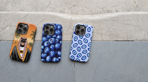 Desert Guardian, Arabesque Saint and Evil Eye iPhone tough cases in a row across a worn stone doorstep